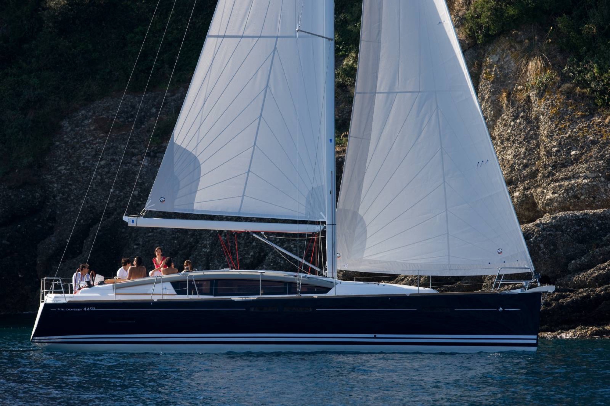 A Sun Odyssey 44 under full sail in clear water