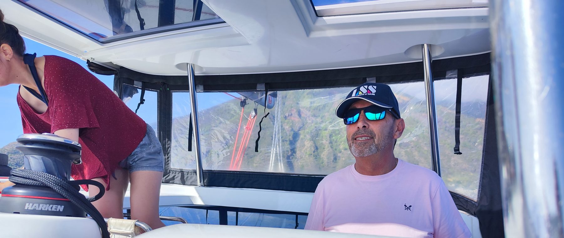 Helmsman at the wheel under the bimini