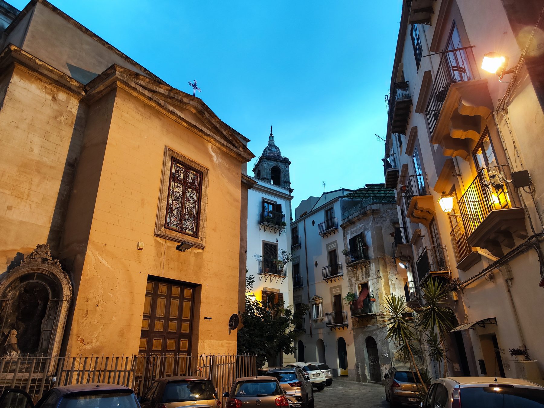 Palermo at twilight — bell tower, narrow street, glowing balconies